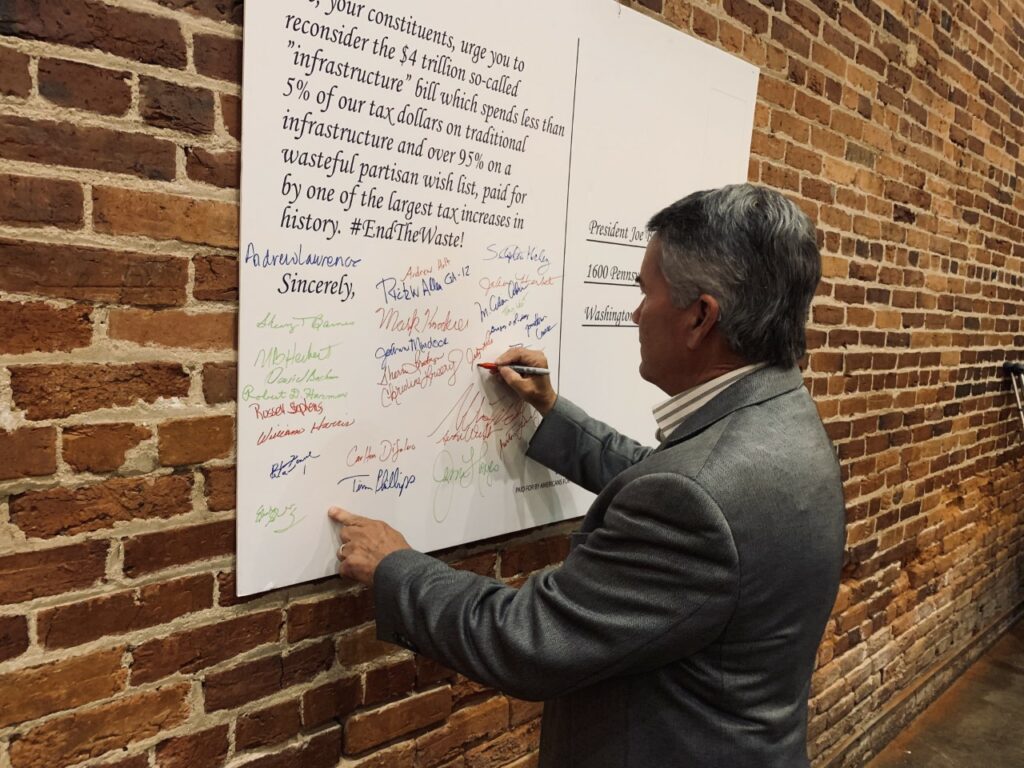 Rep. Jody Hines signs one of AFP's postcards to the president protesting wasteful Washington spending.