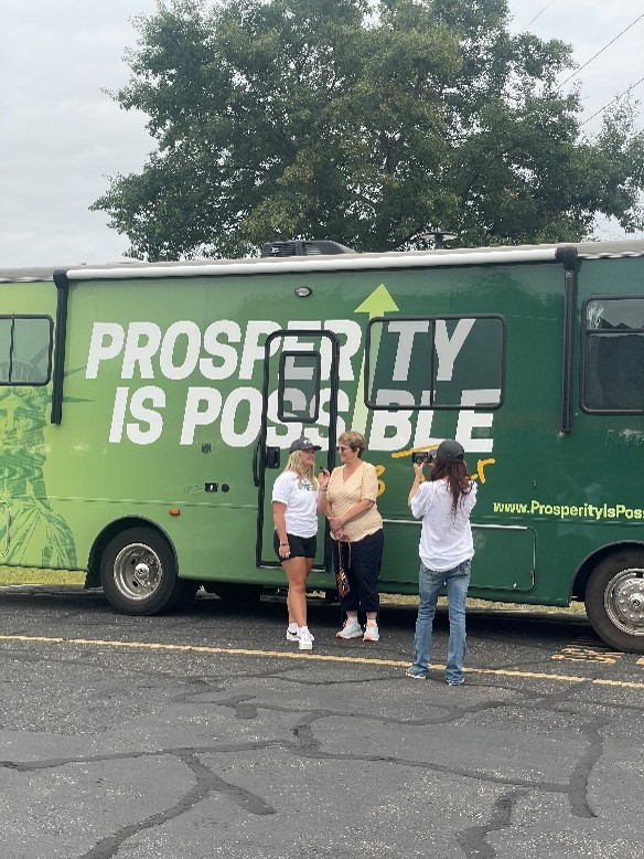 Volunteers take a break near the Prosperity Is Possible RV at the PIP tour stop in Eau Claire, Wisconsin, where the PIP team presented sweet solutions to the chilling economic realities of Bidenomics. 