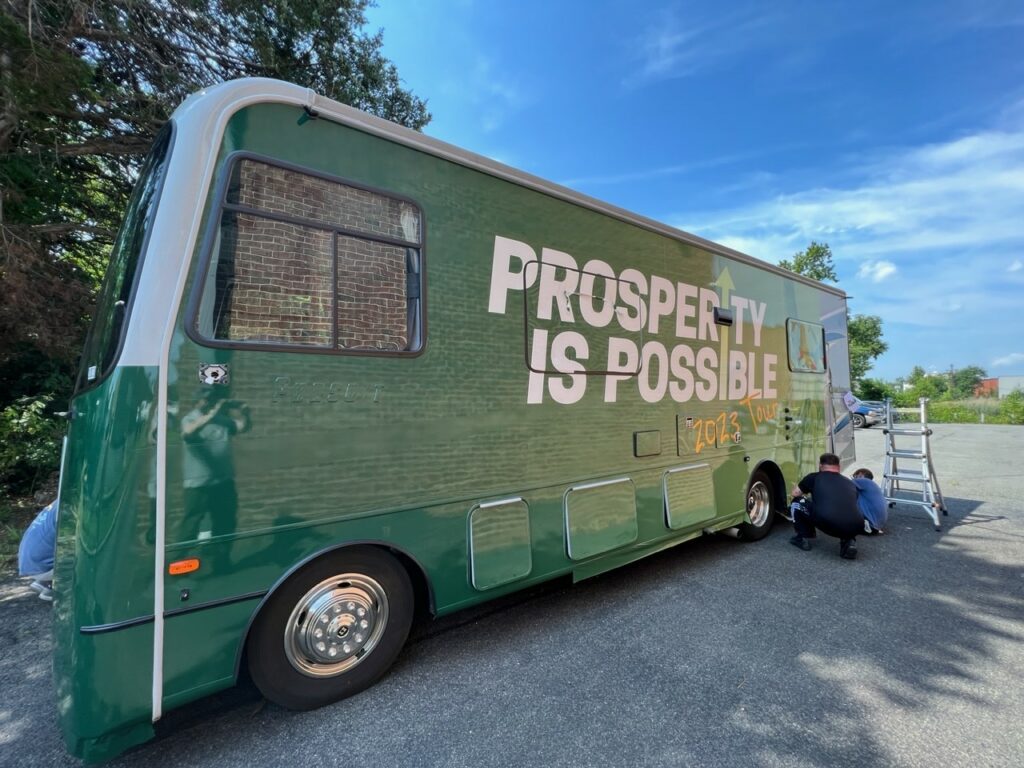 Volunteers put the finishing touches on the Prosperity Is Possible tour bus. 