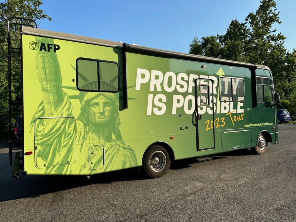 A left-side look of the finished wrap on the Prosperity Is Possible tour bus. 